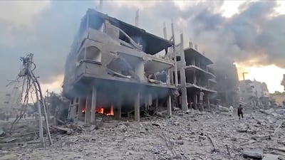 A fire burns underneath a damaged building in Gaza's Jabalia refugee camp after Israeli strikes on the blockaded enclave. Reuters