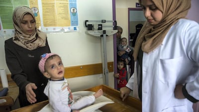 Palestinian child Marah Eljama'al weight is recorded at the at the Ard El Insan clinic in Gaza City.The child is suffering from severe malnutrition and moderate Anemia and weighs just 5.4kg - two kilos below the normal body weight of a child her age.