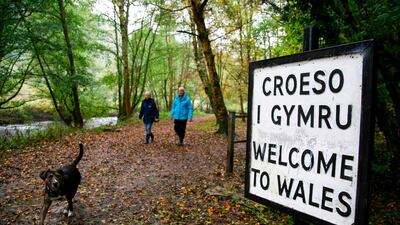 Walkers cross the border between England and Wales in Knighton, a town which sits on the border. AFP