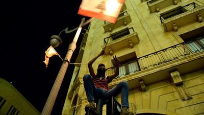 An anti-government protester waves a Lebanese a flag during a protest outside of the Lebanese Parliament in downtown Beirut. EPA
