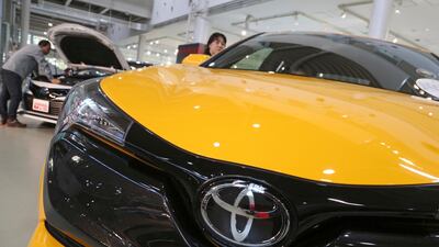 Toyota cars at a showroom in Tokyo. The car maker raised its earnings forecast after reporting that its profit surged. AP