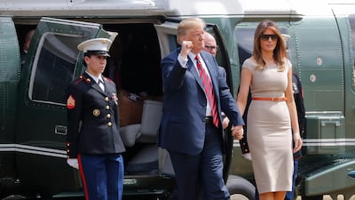 President Donald Trump pumps his fist during his arrival, with first lady Melania Trump, in Regent's Park, near the residence of the US Ambassador. AP Photo
