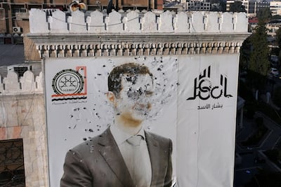 A defaced image of Bashar Al Assad in Hama after the city was captured by opposition forces. AFP
