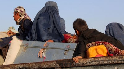 An Afghan woman in a blue burqa sit on the top of a vehicle as after being released by insurgents in the northern province of Sar-i-Pul in 2017. AFP