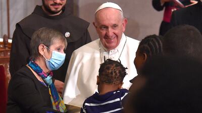 Pope Francis greets a woman holding a child after an ecumenical prayer with migrants. AFP