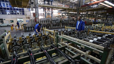 Iranian men work on parts for the Peugeot 206 at the Iran Khodro auto plant. AFP
