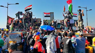 Anti-government protesters gather nea barriers set by Iraqi security forces to close the bridge leading to the Green Zone in Baghdad on November 1, 2019. AP Photo