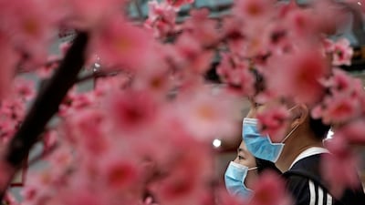 People walk past a New Year decoration in Hong Kong. AP Photo