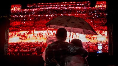 People watch the Rio 2016 Olympics closing ceremony in the rain at the Olympic Boulevard live site. Chris McGrath / Getty Images