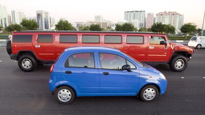 Soon motorists could be driving this blue Chevrolet Spark instead of vehicles like the red Hummer limousine. Jeff Topping / The National
