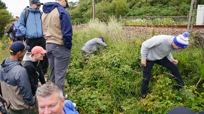 Spectators search for Rory McIlroy's ball, which went out of bounds from the 11th tee. PA