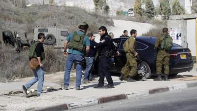Israeli soldiers and police inspect the damaged car of an Israeli settler who ran over and opened fire on a Palestinian girl near the West Bank city of Nablus on November 22. EPA