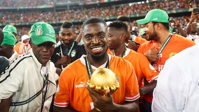 Ivory Coast defender Serge Aurier holds the Africa Cup of Nations trophy after the hosts beat Nigeria 2-1 at Alassane Ouattara Olympic Stadium in Ebimpe, Abidjan on February 11, 2024. AFP