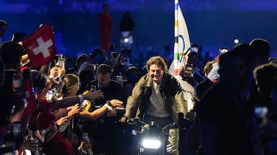Tom Cruise takes the Olympic flag to Los Angeles on a motorbike during the closing ceremony. AP