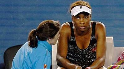 A trainer attends to Venus Williams before she decide to retire against Andrea Petkovic of Germany.