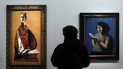 A visitor looks at two paintings, one by Rene Magritte, right, entitled ‘The subdued reader’ (1928) and another by Pablo Picasso entitled ‘Portrait of a woman’ (1928). Francois Guillot/AFP