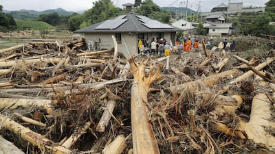 Local residents and rescue workers take part in seach operations for missing people in flood area in Asakura, Fukuoka prefecture, on July 8, 2017. The death toll from heavy rains and flooding in southern Japan has risen to 15, a government official said, as rescuers continued work to evacuate isolated survivors. JAPAN OUT / AFP PHOTO / JIJI PRESS AND AFP PHOTO / STR / Japan OUT