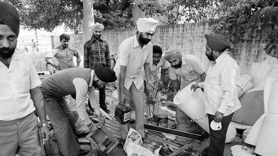 Members of the Indian Sikh community, whose house were burned and robbed by mobs of Hindus collect their looted property in a Delhi police station on November 6, 1984. Peter Kemp / AP