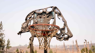 A melted basketball backboard and hoop is seen among the burned remains of Riverside Real Life Church after it burned down during the Old Trails fire in Spokane, Washington. AFP