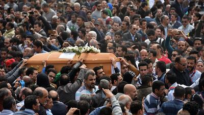 Mourners carry the coffin of one of the victims of the blast at the Coptic Christian Saint Mark's church in Alexandria. Mohamed El-Shahed / AFP