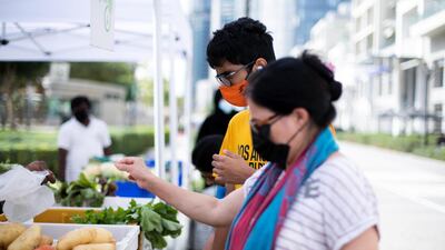 Customers buy fresh vegetables at The Farmer’s Market on the Terrace, held on Bay Avenue in Business Bay, Dubai. Reem Mohammed / The National