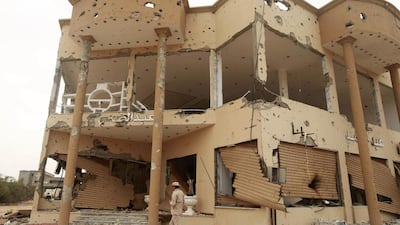 A member of the Libyan pro-government forces walks beside shops damaged during street clashes with the Shura Council of Libyan Revolutionaries. Esam Omran Al-Fetori / Reuters