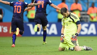 Spain keeper Iker Casillas slumps as Wesley Sneijder (No 10) and Arjen Robben (11) celebrate following Robben's second goal of the game, Netheralnds' fifth, in a 5-1 win over Spain on Friday at the 2014 World Cup in Salvador, Brazil. Javier Soriano / AFP