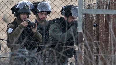 An Israeli soldier takes aim amid clashes with Palestinian protesters in the northern West Bank city of Tulkarem following the funeral of 19-year-old Badr Nafla in the same city. AFP