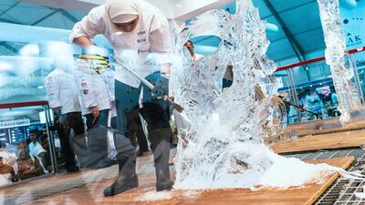 A participant carves creates an ice sculpture during the ice carving event at Gulfood.