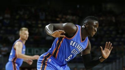 Real Madrid centre Othello Hunter, right, falls in front of Oklahoma City Thunder guard Victor Oladipo. Daniel Ochoa de Olza / AP