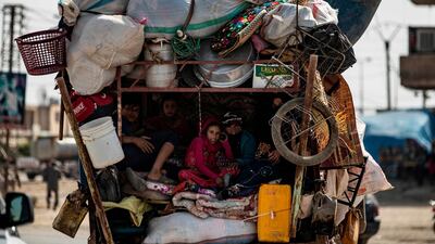 Displaced Syrians sit in the back of a pick up truck as civilians flee amid Turkey's military assault on Kurdish-controlled areas in northeastern Syria. AFP