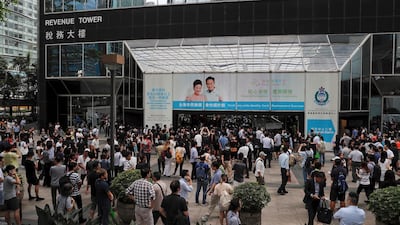 People watch protesters gather at the main entrance of the Hong Kong Revenue Tower in Hong Kong on Monday. AP