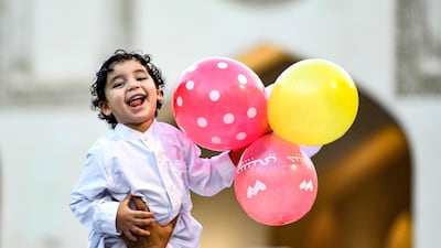 A boy holds balloons after the morning prayers for Eid Al Adha at the Azhar mosque in the centre of Cairo. AFP