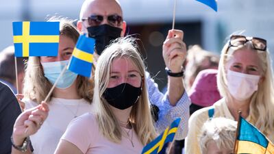 Visitors at Expo 2020 Dubai wave Swedish flags.