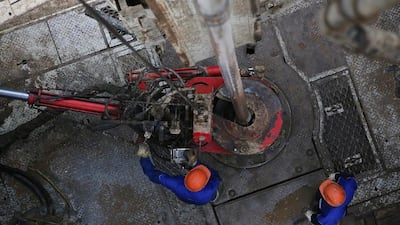 The risks to Russia’s economy triggered by the slide in oil prices will be mitigated by the decline in the rouble, one analyst said. Above, workers drilling pipes to the turntable on an oil drilling tower operated near Almetyevsk, Russia. Andrey Rudakov / Bloomberg