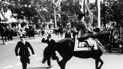 Queen Elizabeth calms her horse Burmese while policemen spring to action after shots were heard as she rode down the Mall in 1981. PA