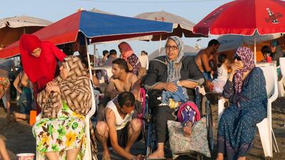 An Algerian family on a public beach, reserved for families, in the capital Algiers on August 3, 2016. Ryad Kramdi / AFP -