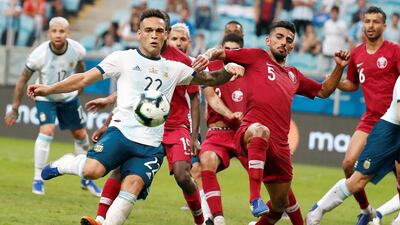 Argentina's Lautaro Martinez vies for the ball with Qatar's Tarek Salman. EPA