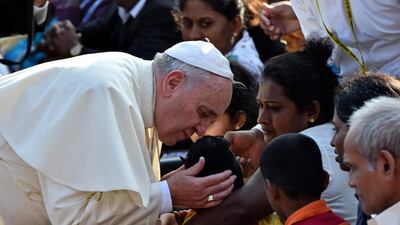 Pope Francis kisses a sick child before a canonisation mass for Joseph Vaz in the Sri Lankan capital Colombo on January 14, 2015. AFP