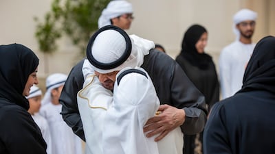 Sheikh Mohamed warmly embraces a child at the reception