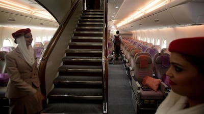 Emirates Airline stewardesses at the foot of the A380 superjumbo's cruise liner-style staircase. Airbus may do away with the hallmark feature to boost capacity and efficiency in new models. AP Photo / Manish Swarup