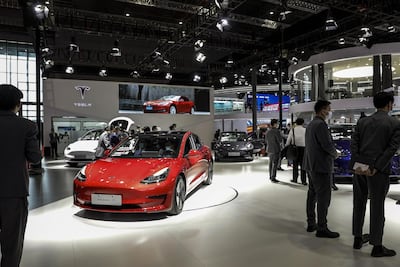 Visitors walk past Chinese-made Tesla EVs at the company's booth at the Auto Shanghai 2021 show on Monday. Bloomberg