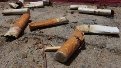 Cigarette butts are tossed on the ground at Baynunah Park in Abu Dhabi. Delores Johnson / The National