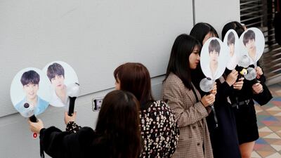 People take their photos with fans bearing photos of the members of South Korean boy band BTS outside Tokyo Dome where the band's concert will be held in Tokyo, Japan. Kim Kyung-Hoon / Reuters