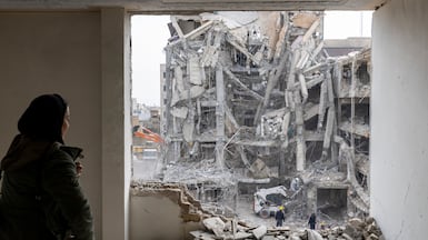 A woman looks out upon residential buildings that were destroyed a few days ago following the US and Israeli attack in in Tehran, Iran. Getty Images