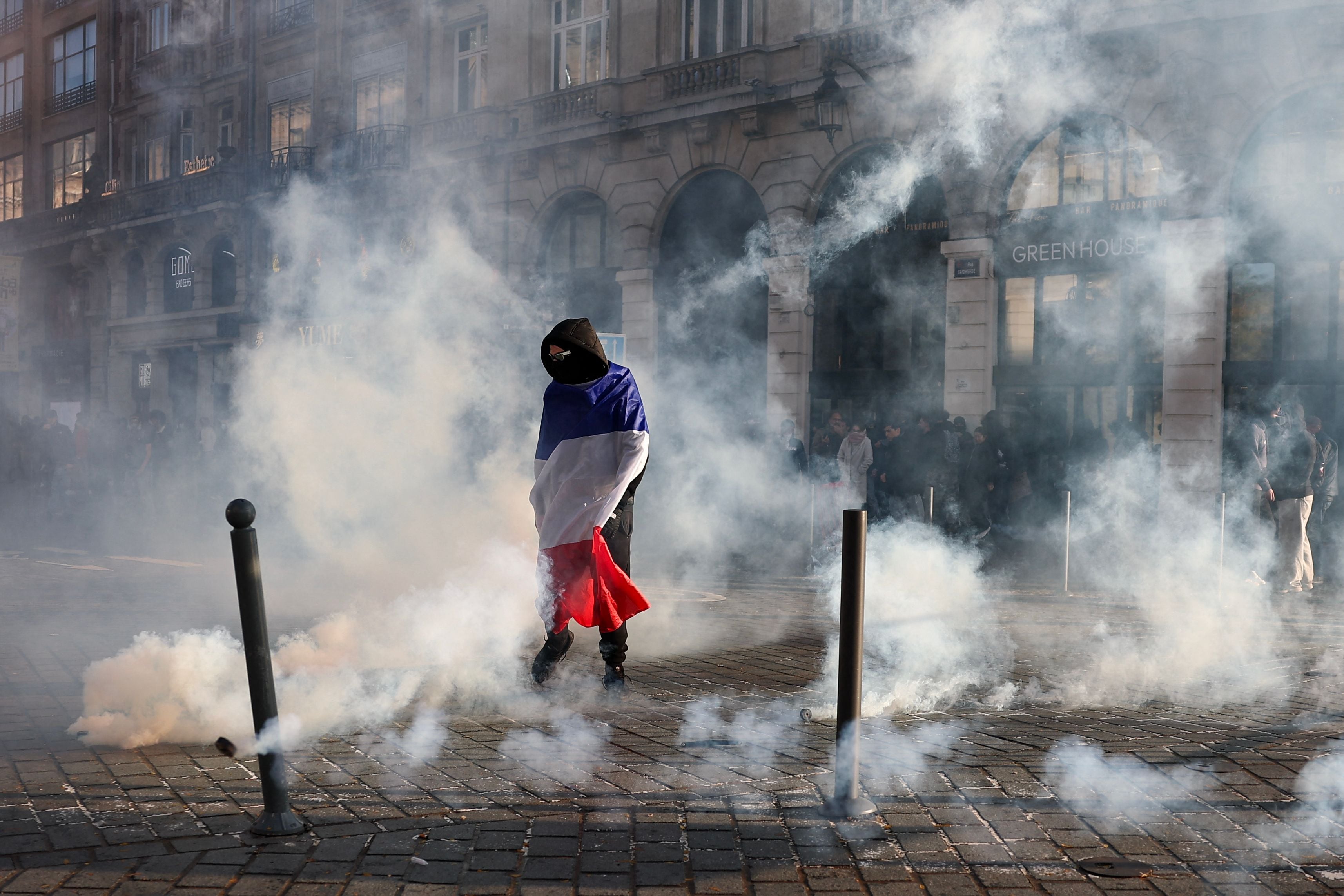 A protester wrapped in the French flag at the at smoke-filled Place de l'Opera in Lille. AFP