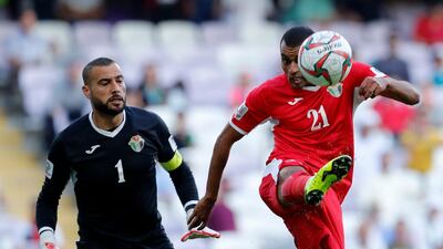 Jordan's defender Salem Al Ajalin, right, clears the ball next to goalkeeper Amer Shafi. AP Photo