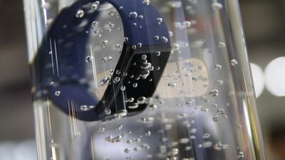 An Amazfit fitness tracker device sits submerged in water to demonstrate its water resistance on the Xiaomi stand at MWC. Bloomberg