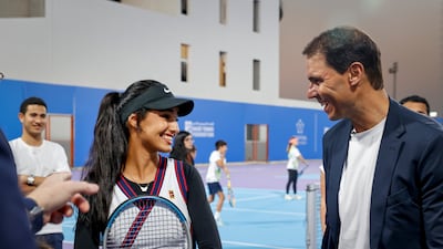 Rafael Nadal speaks to a young tennis player during a tennis clinic held at Mahd Academy.