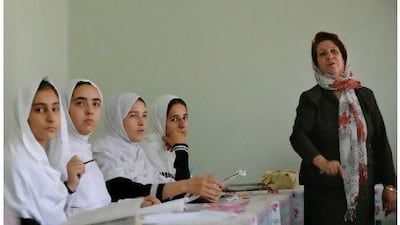 An Afghan teacher and students during a class in Kabul. Women's rights have undoubtedly improved in Afghanistan since the Taliban were ousted. Under the Taliban, girls' schools were closed down while women were banned from working outside the home and forced to wear the burqa. ADEK BERRY / AFP Photo